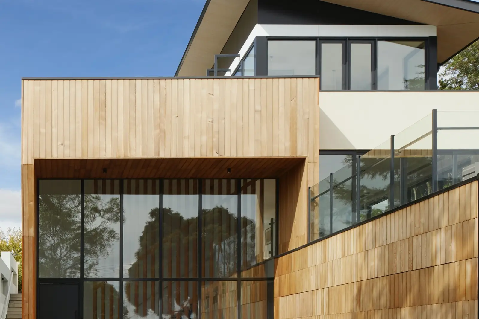 Timber-clad house with a full-height grid of glass windows