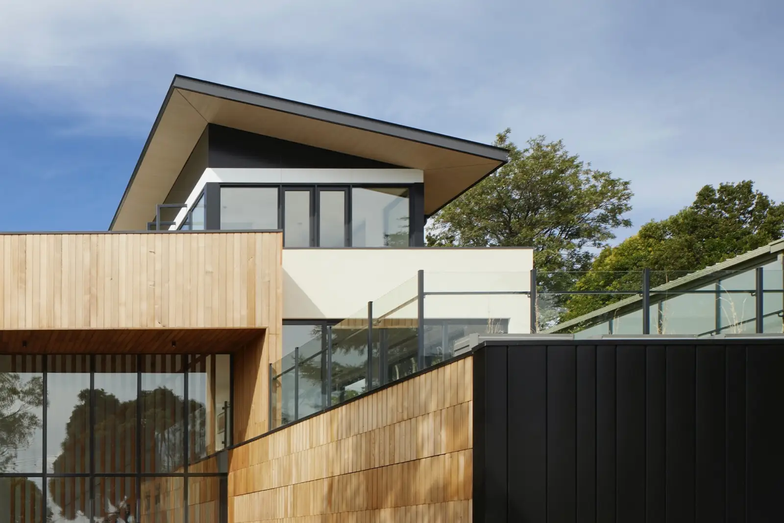 Modern house facade with timber cladding and large glass windows